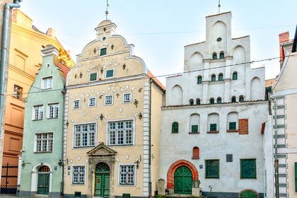 Kolorowe fasady trzech zabytkowych kamienic w Rydze.