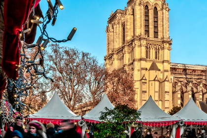 Jarmark bożonarodzeniowy na tle katedry Notre-Dame w Paryżu.