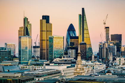 Panorama Londynu z wieżowcami, m.in. The Gherkin, w blasku zachodzącego słońca.