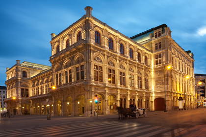Opera Wiedeńska nocą i przejeżdżająca dorożka.