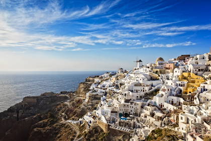 Oia na Santorini w słoneczny dzień. Widok na białe budynki i wiatraki.