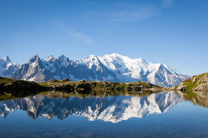 Górski krajobraz z jeziorem, w którym odbija się Mont Blanc.