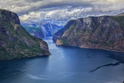 Fiord z wysokimi klifami i łodziami.