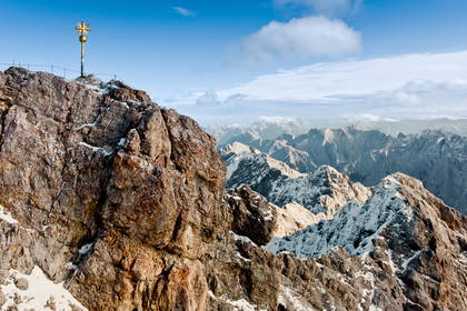 Widok na szczyt Zugspitze z krzyżem i górską panoramą.