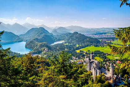 Zamek Neuschwanstein z widokiem na góry i jeziora.