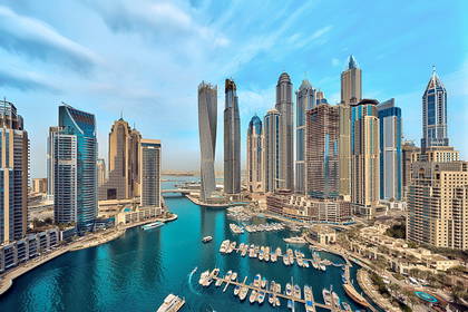 Panorama Dubai Marina: wieżowce, jachty i błękitna woda.