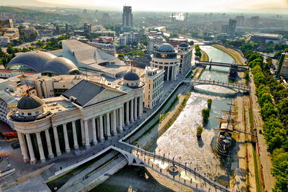 Panorama Skopje z rzeką Wardar i budynkami w tle.