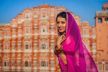 Kobieta w sari na tle pałacu Hawa Mahal w Jaipurze.