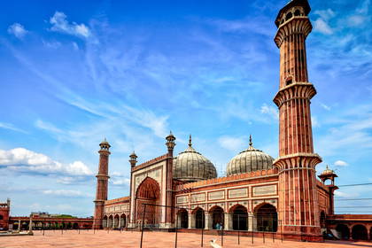 Jama Masjid w Delhi z minaretami i kopułami na tle nieba.
