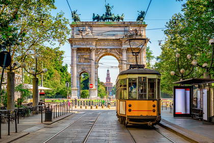 Żółty tramwaj na tle Arco della Pace w Mediolanie.