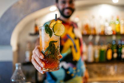 Barman z drinkiem w dłoni.