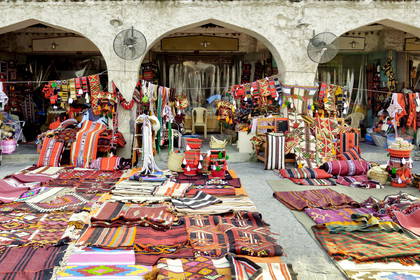 Kolorowe dywany i tkaniny na targu Suk Al-Waqif w Katarze.