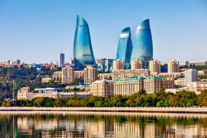Panorama Baku w Azerbejdżanie z wieżami Flame Towers odbijającymi się w wodzie.