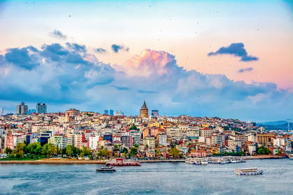 Panorama Stambułu z wieżą Galata i łodziami na wodzie.