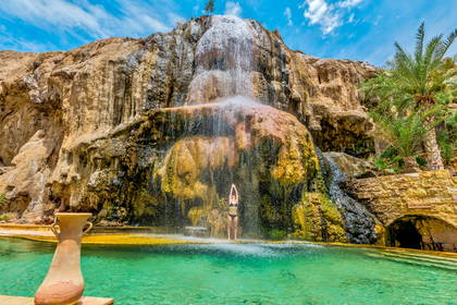 Kobieta relaksuje się pod wodospadem Ma'in Hot Springs w Jordanii.