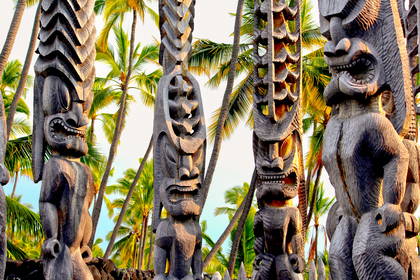 Posągi Tiki na tle palm.
