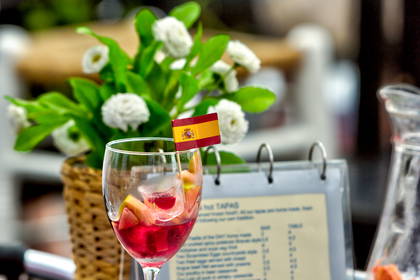 Kieliszek sangrii i hiszpańska flaga na stole w restauracji.