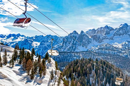 Kolejka linowa w Dolomitach z widokiem na góry.