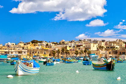 Kolorowe łodzie rybackie w zatoce Marsaxlokk, Malta.