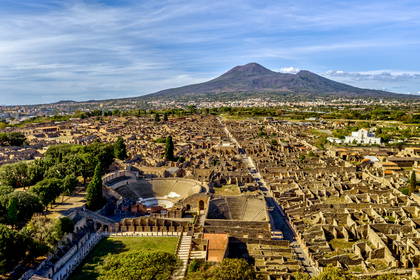 Panorama ruin starożytnych Pompejów z Wezuwiuszem w tle.