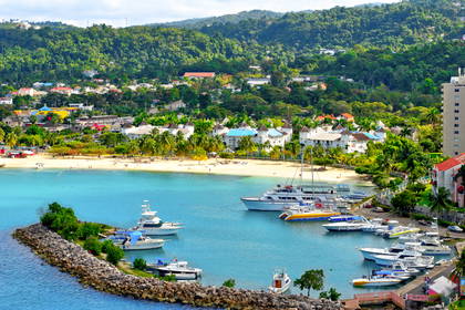 Ocho Rios na Jamajce: turkusowa zatoka z łodziami, piaszczysta plaża i miasto na tle zalesionych wzgórz.