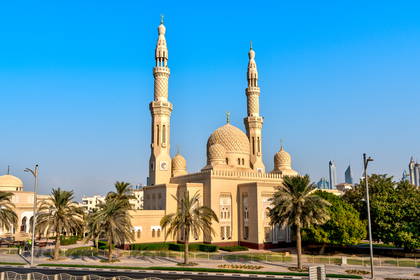 Beżowy meczet Jumeirah z wysokimi minaretami i kopułami.
