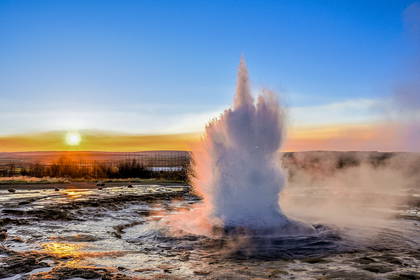 Erupcja gejzera Strokkur w Islandii o zachodzie słońca.