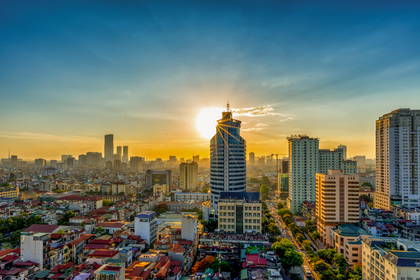 Panorama Hanoi o wschodzie słońca z widokiem na wieżowce i dachy budynków.