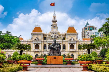 Ratusz w Ho Chi Minh z wietnamską flagą i pomnikiem.