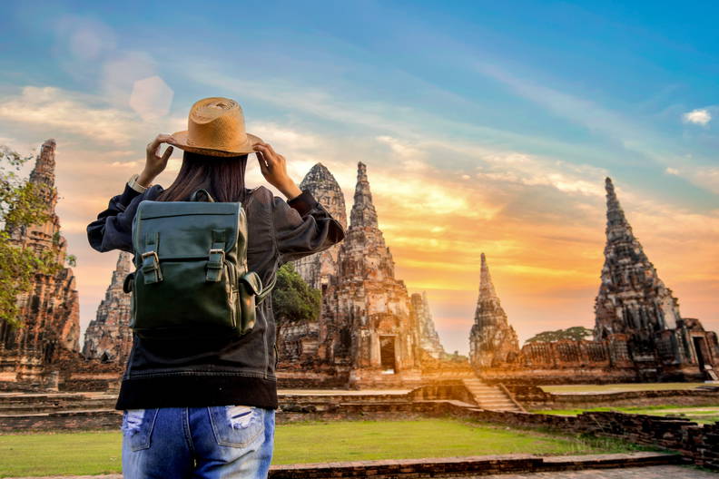 Turystka w kapeluszu i z plecakiem zwiedza Wat Chaiwatthanaram w Ayutthayi.