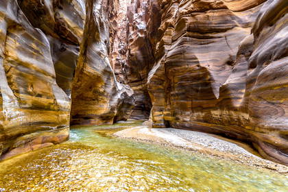 Wadi Mujib, Jordania: wąski kanion z rzeką pomiędzy skalnymi ścianami.