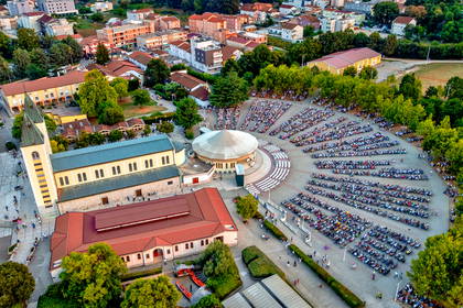 Widok z lotu ptaka na kościół św. Jakuba w Medjugorje i tłum wiernych przed ołtarzem zewnętrznym.