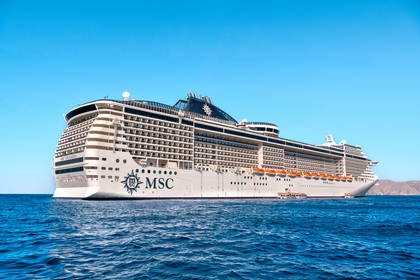 Statek wycieczkowy MSC Splendida płynie po błękitnym morzu pod bezchmurnym niebem.