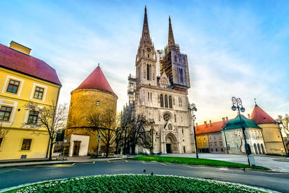 Poranny widok z placu na Katedrę w Zagrzebiu z dwiema strzelistymi wieżami i okrągłą basztę.